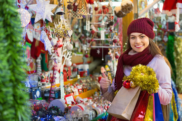 Beautiful young woman choosing Christmas decoration