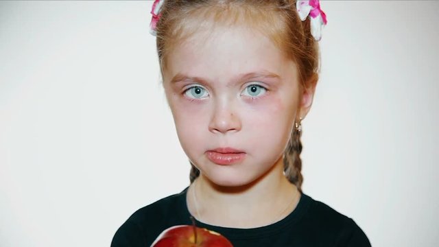 sad little girl eats a apple