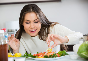 Obraz na płótnie Canvas Girl decorating prepared dish of shrimps