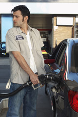 Gas station worker refueling car at petrol station