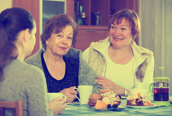 Young female and mature women drinking tea and talking