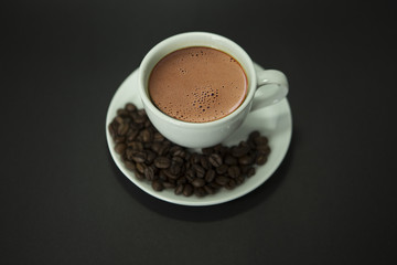 Top view, coffee cup and coffee beans on black background.