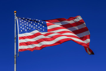 American flag waving in clear blue sky