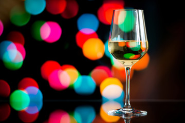 glass of white wine against a glowing bokeh - copy space, select