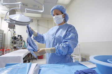 Female nurse preparing bed in operation theatre