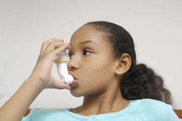 Closeup of a girl using asthma inhaler