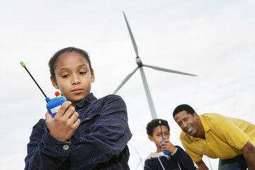 Father and children playing with walkie-talkies at wind farm