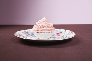 Pink cupcake on table isolated over pink background