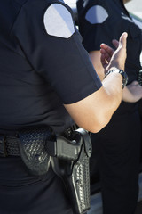 Midsection of a police officer in uniform with automatic pistol