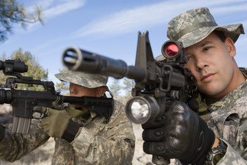 Fototapeta premium Two US army soldiers aiming with machine guns on a mission