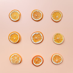 Dried orange slices patterned over green background, top view. Flat lay