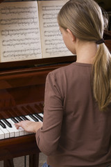 Rear view of a teenage girl playing the piano © MDBPIXS
