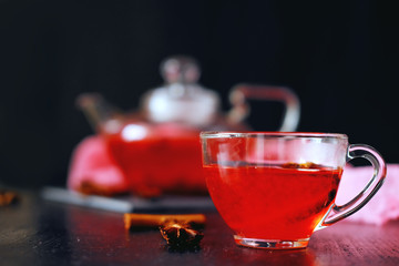 Cranberry herbal hot tea drink in glass teapot with cinnamon and