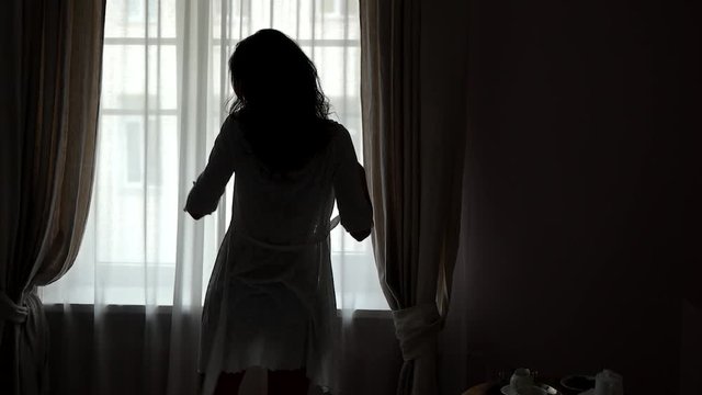 Girl near window in slow-mo. Lady taking off nightie. Beauty will save the world. Grace and sexuality.