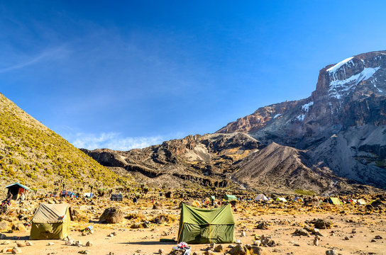 Stunning view of Baranco Camp (3900m amsl) on route to the summit of Mount Kilimanjaro, Kibo with Uhuru Peak at 5895m amsl in the background.Tents and unrecognizable hikers in the background.Tanzania.