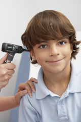 Portrait of a preadolescent boy having his ear examined