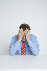 Frustrated businessman with hands on head isolated over white background