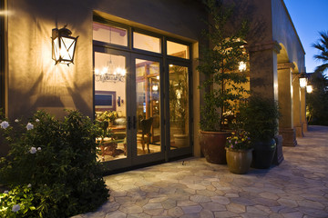 House exterior with view into living room at dusk