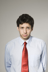 Portrait of a worried young businessman isolated over grey background
