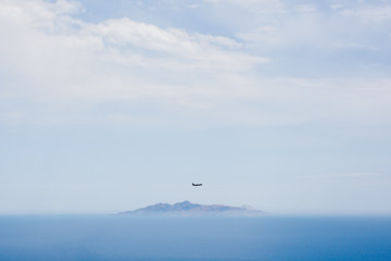 Fototapeta na wymiar Plane flying over an island