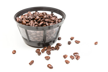 Reusable coffee filter filled with beans isolated on white background