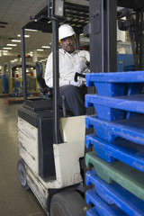 Fototapeta na wymiar Portrait of a man sitting in forklift truck at newspaper factory