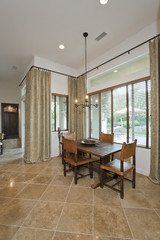 Four chairs with dining table on tiled floor in modern house