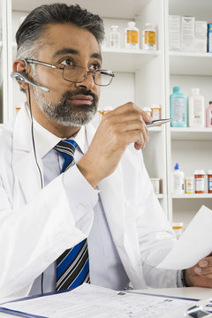 Middle Aged Indian Male Pharmacist Working In Pharmacy