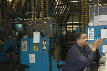 Side view of a worker in the newspaper factory