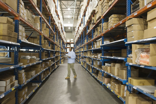 Blurred man inspecting boxes in distribution warehouse
