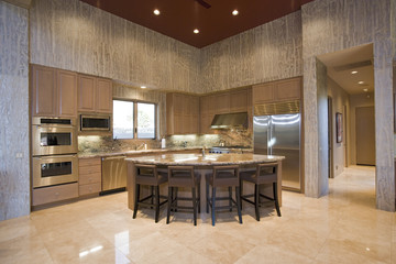 View of a spacious kitchen with stools at the island in modern house