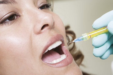 Extreme closeup of dentist inspecting female patient's teeth