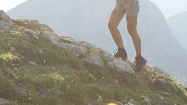 CLOSE UP: Unrecognizable female in leather mountaineering boots hiking uphill