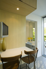 Closeup of two chairs and table by television in the kitchen