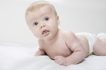 Closeup portrait of a cute baby boy lying in bed