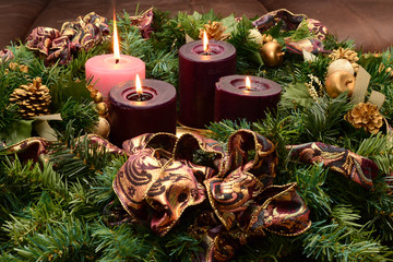 Traditional Advent wreath on rustic table with candles glowing warm