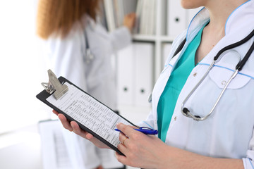 Close-up of a female doctor while filling up medical application form