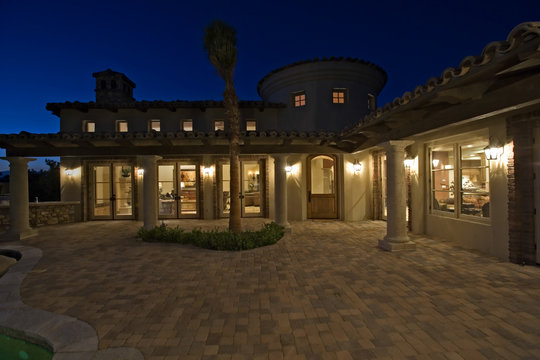 Exterior Shot Of An Illuminated Neoclassical House At Dusk