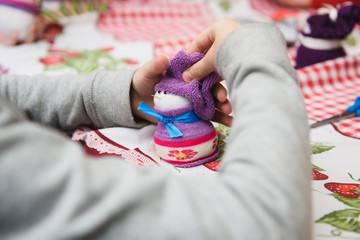 Happy kid doing craft. Small child holding a felt Christmas snowman in hands. Workplace in...
