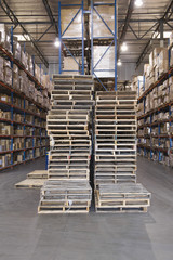 Obraz premium Wooden pallets and cardboard boxes stacked in distribution warehouse