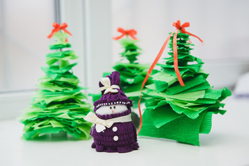 Christmas handicrafts. Christmas decoration, snowman on white background with Christmas tree.