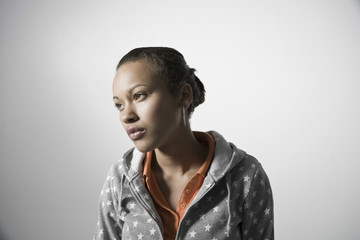 Thoughtful woman looking away against gray background