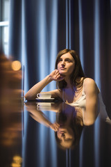 Thoughtful young woman with reflection on table relaxing in cafe