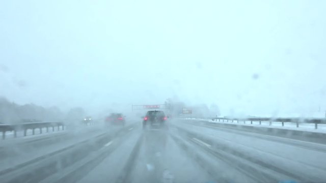 FPV: Car driving in snowdrift on slippery frosty road in bad weather condition