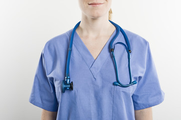 Midsection of a female surgeon with stethoscope wearing around neck isolated over white background