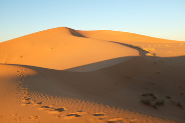 Fototapeta na wymiar Desert Dune with Footsteps in the Evening
