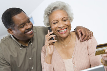 Happy African American couple shopping online through credit card