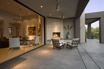 Foto op Canvas Zicht op stoelen bij de open haard in de patio van een modern huis © moodboard