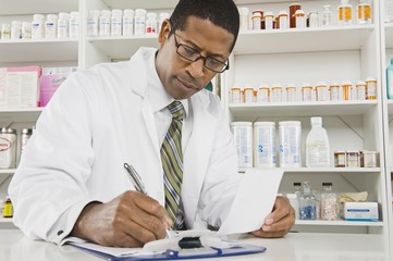 African American male pharmacist working in pharmacy