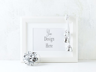 A white image frame and silver Christmas decorations